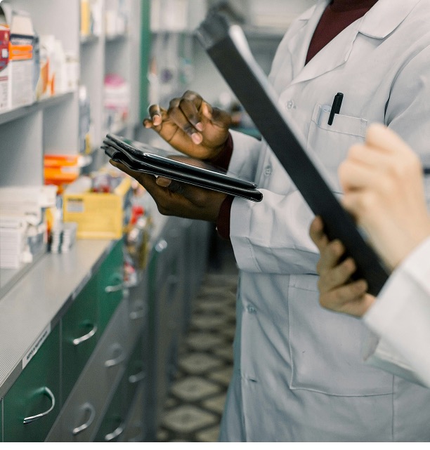 Pharmacist team reviewing medication inventory with tablets
