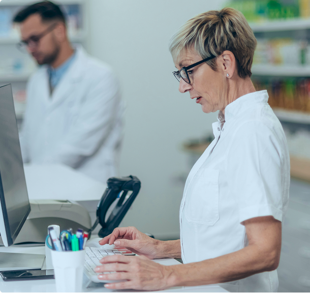 Pharmacist reviewing information at a workstation in a pharmacy